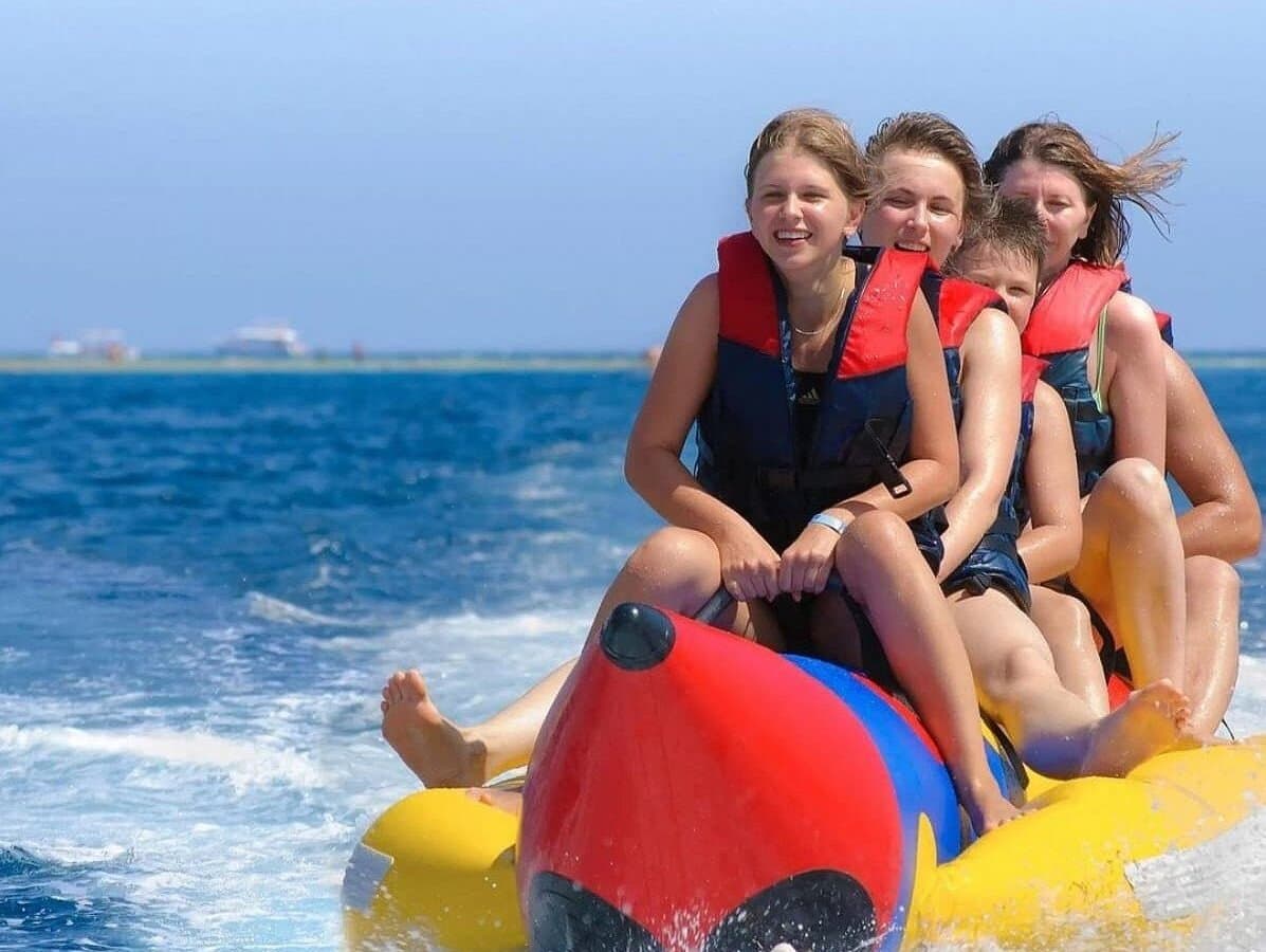 Family laughing on a banana boat ride across the open sea